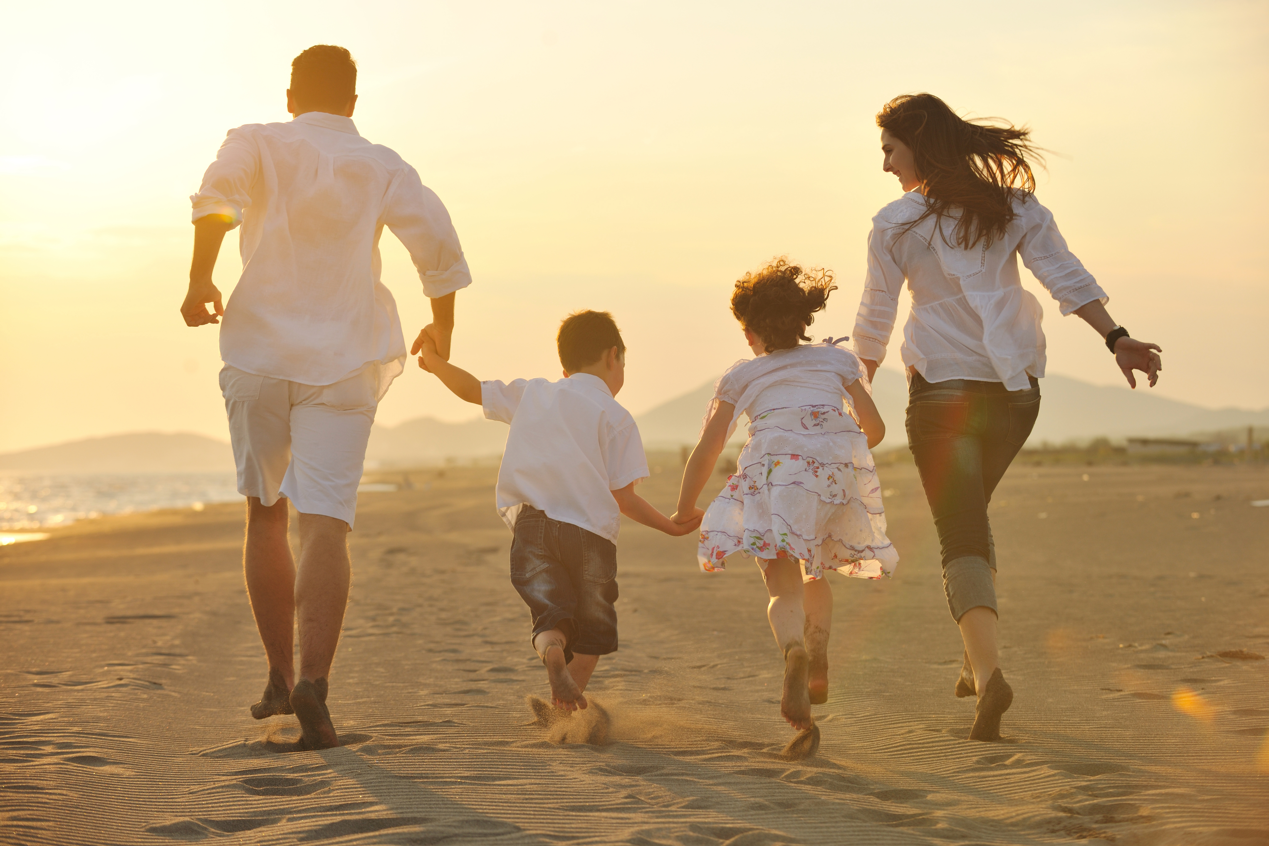 A family running together on the beach